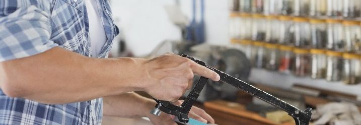 Mann sägt Kunststoffrohr mit Handsäge